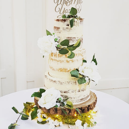 Three tier semi naked wedding cake with fake flowers